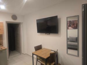 a room with a table and a television on a wall at La Piccola Italia in Deggingen