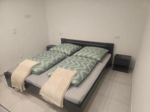 a bed in a room with two pillows on it at La Piccola Italia in Deggingen