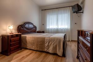 a bedroom with a bed and a dresser and a window at Casa do Centro in Peniche