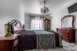 a bedroom with a bed and a dresser and a mirror at Casa do Centro in Peniche