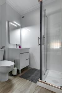 a bathroom with a toilet and a glass shower at Casa do Centro in Peniche