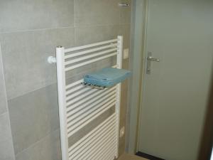 a bathroom with a white door with a blue stool at B&B Vallis Dyliae in Korbeek-Dijle +44 photos