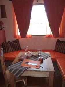 una mesa con dos copas de vino y un libro sobre ella en Mamuna Casas Loft en Uspallata