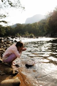 a young boy is playing on the rocks near a river at Chácara bello Rio in Guaratuba +73 photos