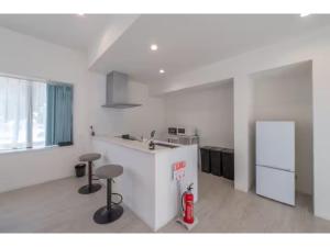 a kitchen with a counter and stools in a room at Turtle Two Three - Vacation STAY 87759v in Miyako-jima