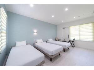 a room with three beds and a window at Turtle Two Three - Vacation STAY 87759v in Miyako-jima