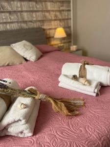 a pink bed with towels and a bow on it at CASA AZZURRA in Imperia +25 photos