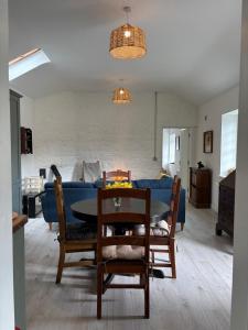 a living room with a table and a blue couch at Carpenters Cottage in Rathvilly +22 photos