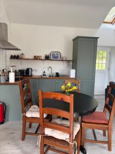 a kitchen with a table and chairs and a counter at Carpenters Cottage in Rathvilly
