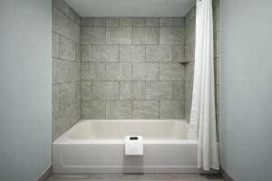 a white bath tub in a bathroom with a shower at Quarters Inn & Suites in Antioch +32 photos