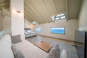 a living room with a couch and a table at Hellosummer Boutique suites,near fiscardo! in Andipáta Erísou