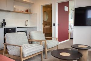 a living room with two chairs and a tv at The Sea Breeze in Timaru