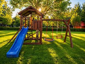 a playground with a slide and a swing at Swan Apartman in Sándorfalva