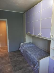 a bedroom with a bed and purple cabinets at Giardino sul lago, La Vigna in Nesso