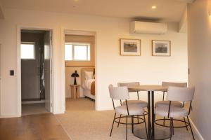 a room with a table and chairs and a bedroom at The Sea Breeze in Timaru