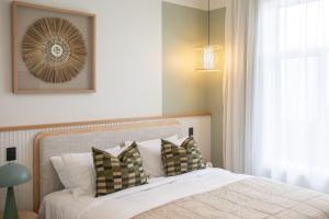 a bedroom with a bed with pillows and a window at The Sea Breeze in Timaru
