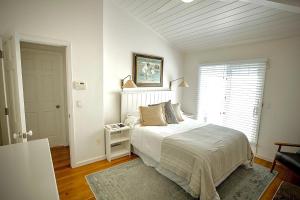 a white bedroom with a bed and a window at Beachbound Bliss in Del Mar in San Diego
