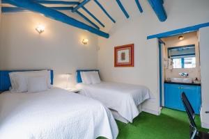 two beds in a room with green floors and ceilings at Casa azul in Villa de Leyva +43 photos