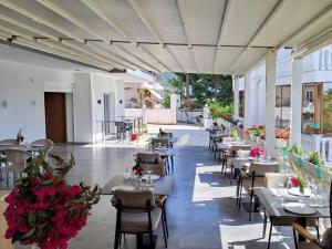 a restaurant with tables and chairs and flowers at Vila REJANA in Ksamil