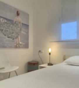 a bedroom with a bed and a picture of a woman in a dress at Ático dúplex - 1ª Linea playa in Adra