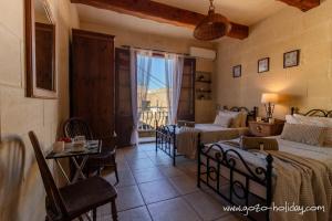 a bedroom with two beds and a living room with a window at Ta Lilly Xaghra in Xagħra +15 photos