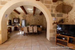 a kitchen and dining room with a table and a tv at Ta Lilly Xaghra in Xagħra