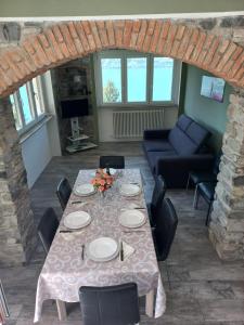 a dining room with a table with chairs and a couch at Giardino sul lago, La Vigna in Nesso +27 photos