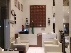 a lobby with a counter and chairs and a clock at دارين1 - اوبرا جولد سابقا in Muhayil