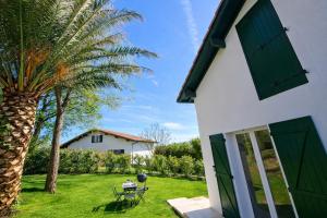 a house with a palm tree and a table and a grill at Palmito in Bidart