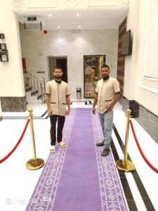 two men are walking down a purple carpet at دارين1 - اوبرا جولد سابقا in Muhayil