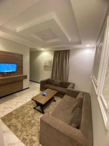 a living room with a couch and a tv at دارين1 - اوبرا جولد سابقا in Muhayil +8 photos