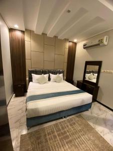 a bedroom with a large bed and a mirror at دارين1 - اوبرا جولد سابقا in Muhayil