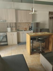 a large kitchen with a wooden island in the middle at The Spot 1 in Larisa