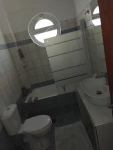 a small bathroom with a toilet and a sink at The Spot 1 in Larisa
