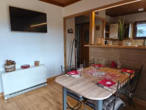 a dining room with a wooden table with red napkins at Le chalet de Maryvonne in Gibles