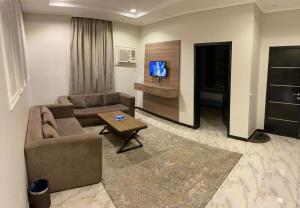 a living room with a couch and a tv at دارين1 - اوبرا جولد سابقا in Muhayil