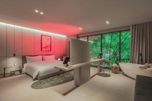 a bedroom with a bed and a tv and a tub at Wake BioHotel, a Member of Design Hotels in Medellín +26 photos