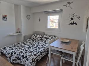 a bedroom with a bed and a table and a desk at Appartamento Aurora - Passo del Tonale in Passo del Tonale