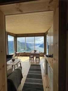 a living room with a table and a large window at Raaum Gard, hytte 3 in Luster