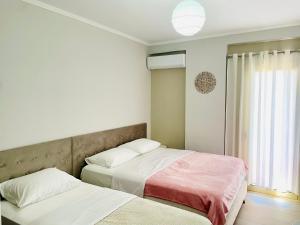 two beds sitting next to each other in a bedroom at Nova City Center in Divjakë