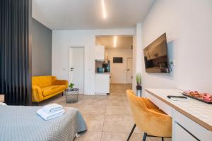 a room with a bed and a kitchen with a yellow couch at Old Town Apartments Brătianu - City Center Stay in Bucharest
