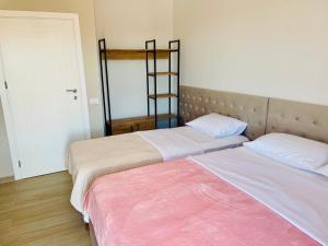 two beds sitting next to each other in a room at Nova City Center in Divjakë