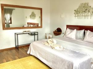 a bedroom with a large white bed with a mirror at Casa Vitto in Tinajo