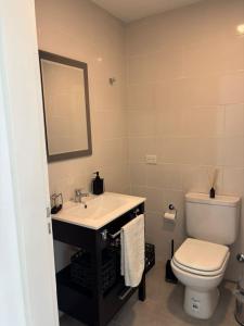 a bathroom with a toilet and a sink and a mirror at Altamar a metros del Hospital Regional y Cabin in Comodoro Rivadavia +3 photos
