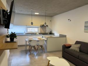 a kitchen and living room with a table and a couch at Altamar a metros del Hospital Regional y Cabin in Comodoro Rivadavia