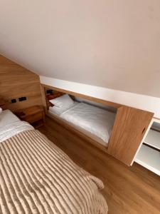 a small bedroom with a bed and a wooden floor at Haus Orion in Eupen