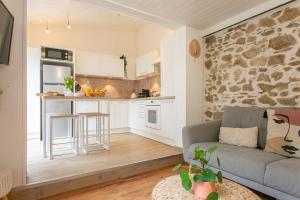 a living room with a couch and a kitchen at Maison Centre ville in La Roche-sur-Yon