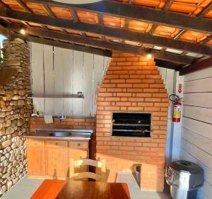 a kitchen with a table and a brick oven at 3 400m Centro de Bombinhas in Bombinhas +4 photos