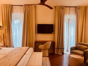 a bedroom with a bed and a tv and a chair at Hotel Villa Ruy López in Zafra