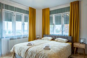 a bedroom with a bed with yellow curtains and windows at OPG Kuzmanović in Goljak